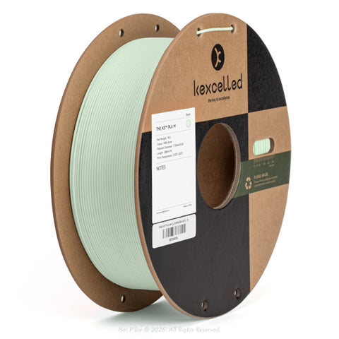 Reel of matte milk green PLA 3D printing filament on a recycled cardboard spool, shown from a three-quarter front view angle with a white background.